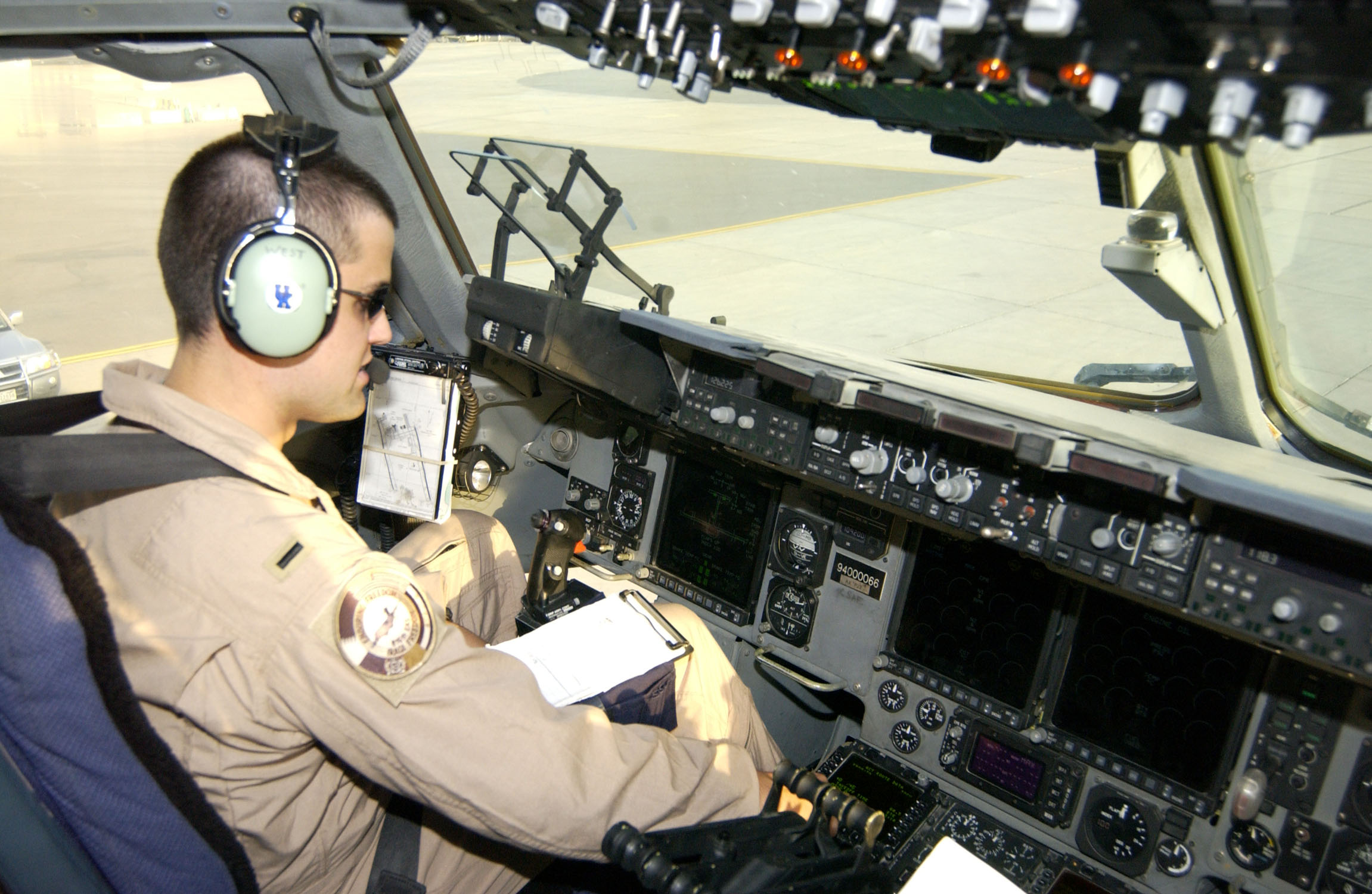 Male military pilot in an aircraft flight deck (cockpit) working on the preflight checklist